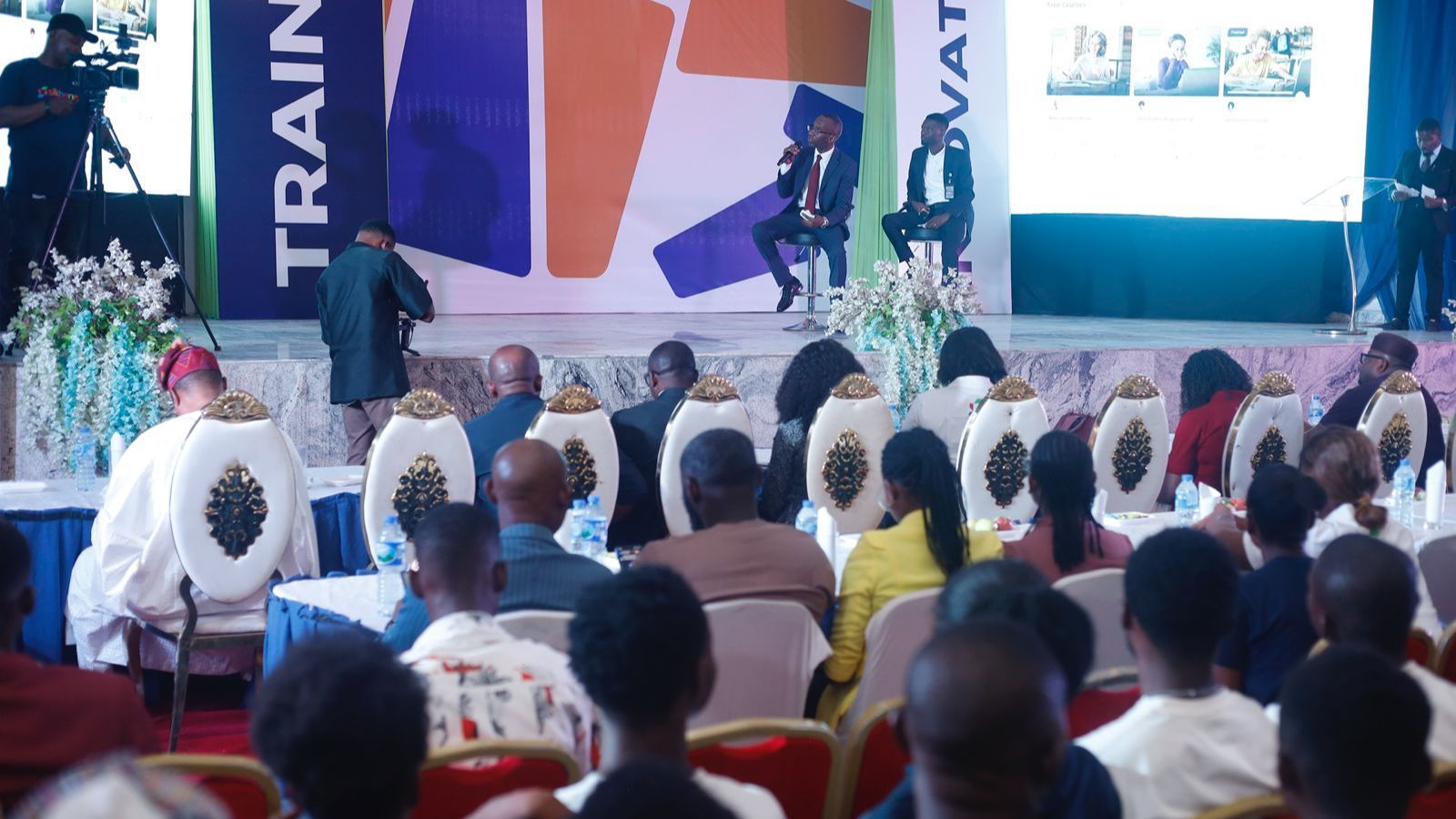 A group of people sitting together, interacting in an event setting.